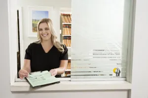 A patient care coordinator holding out a form