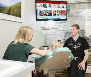 Dr. Mynsberge and an assistant talking with a child patient